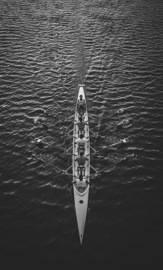 People rowing a row boat on water
